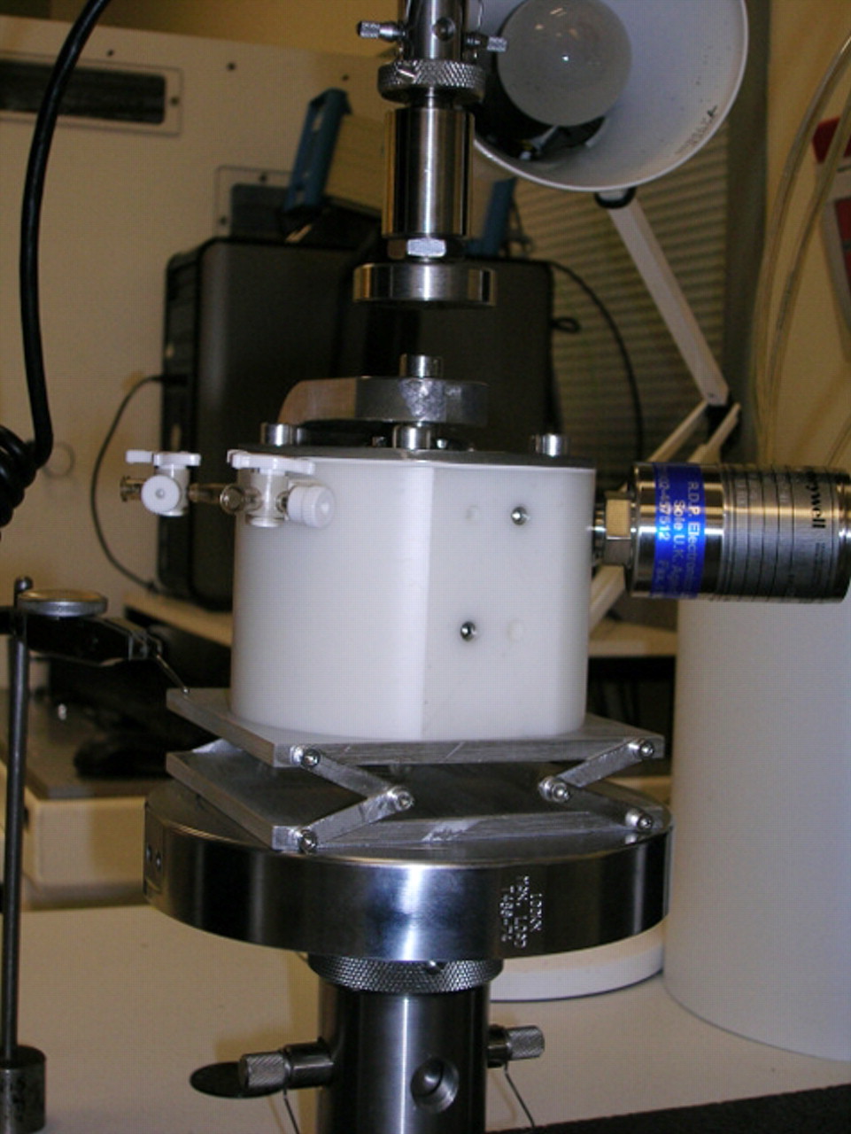 Figs. 5a - 5b 
            Photographs of the mechanical testing,
showing a) the external view, with the resurfacing components assembled
in a specially designed cell with the acetabular component mounted
horizontally and secured with acrylic cement and the head mounted
on a metallic taper, concentrically, above the cup, and b) the internal
view: the cup was filled with water and covered with a silicone
membrane in order to simulate the capsule of the hip.
          